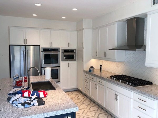 Kitchen appliance suite installation: refrigerator, wall ovens and cooktop with hood