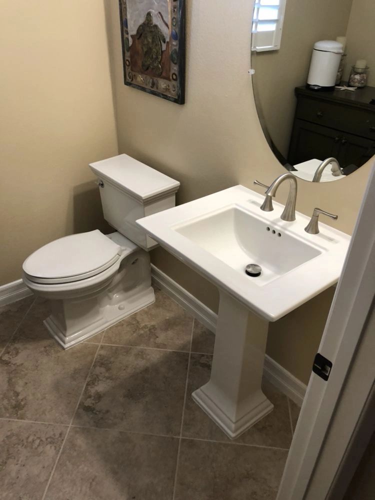 Toilet and pedestal sink faucet installed in a bathroom
