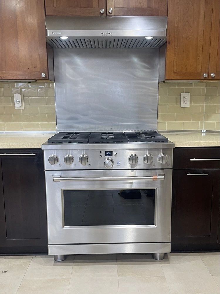 Stainless pro-style range and vent hood installed in a kitchen